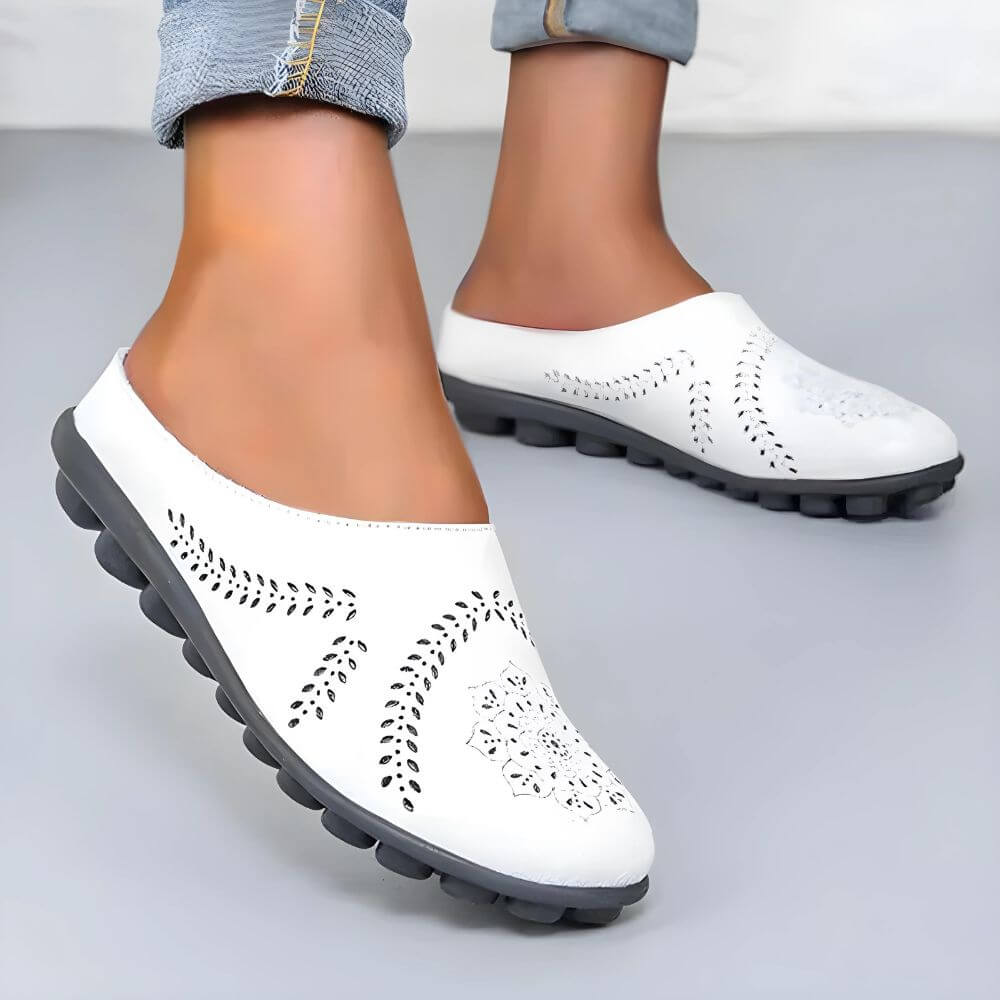 Komfortable weiße orthopädische Slipper auf modernem Untergrund