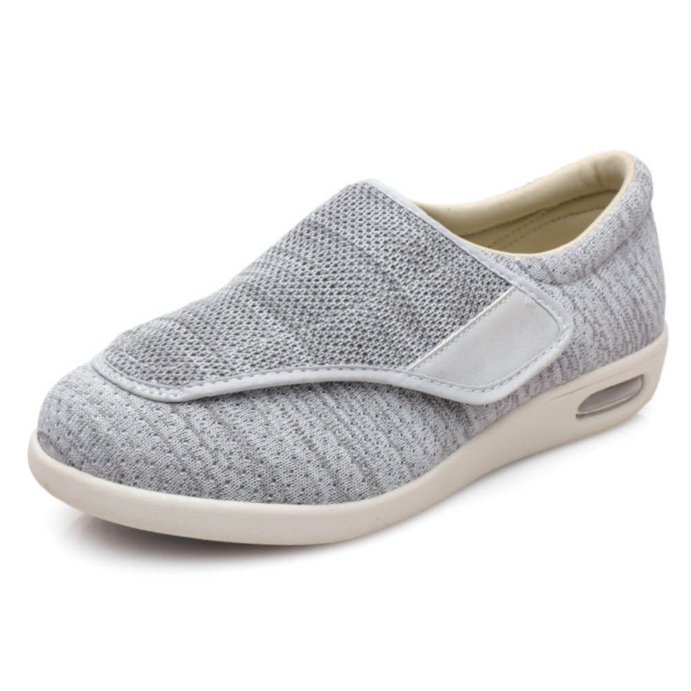 Graue Schuhe mit atmungsaktivem Mesh-Obermaterial und elastischem Klettverschluss für einfachen Tragekomfort.