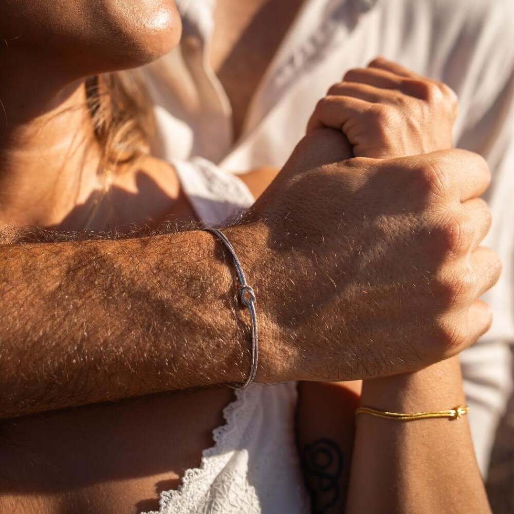 Romantische Partnerarmbänder mit Infinity-Knoten in Gold und Silber – Symbol für Liebe und Verbundenheit.