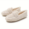 Paar beige Plüsch-Loafers mit strukturierter Oberfläche und rutschfester Sohle auf weißem Hintergrund.